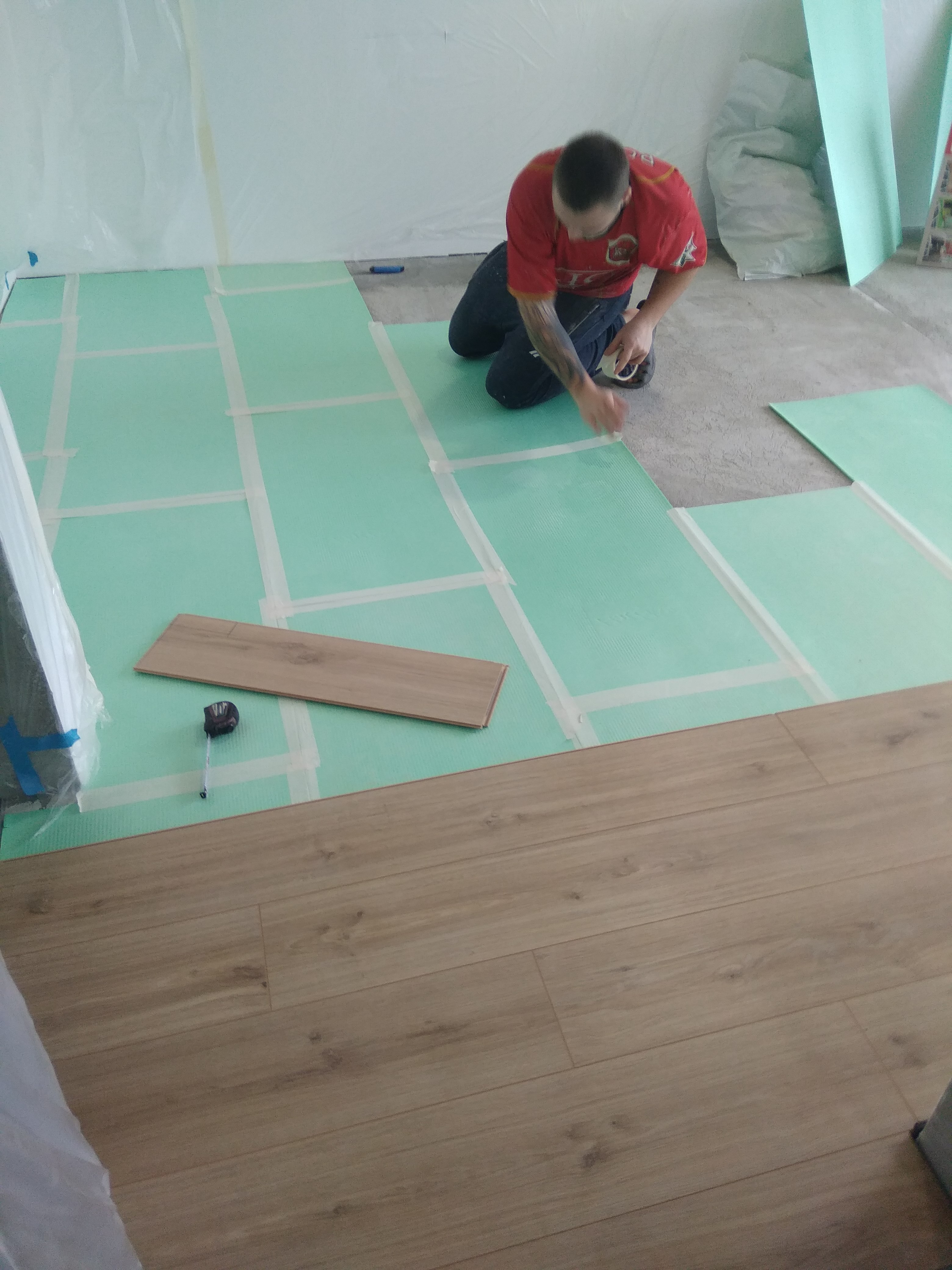 Pose d’un sol stratifié sur sous-couche pendant un chantier LIGNÉRA